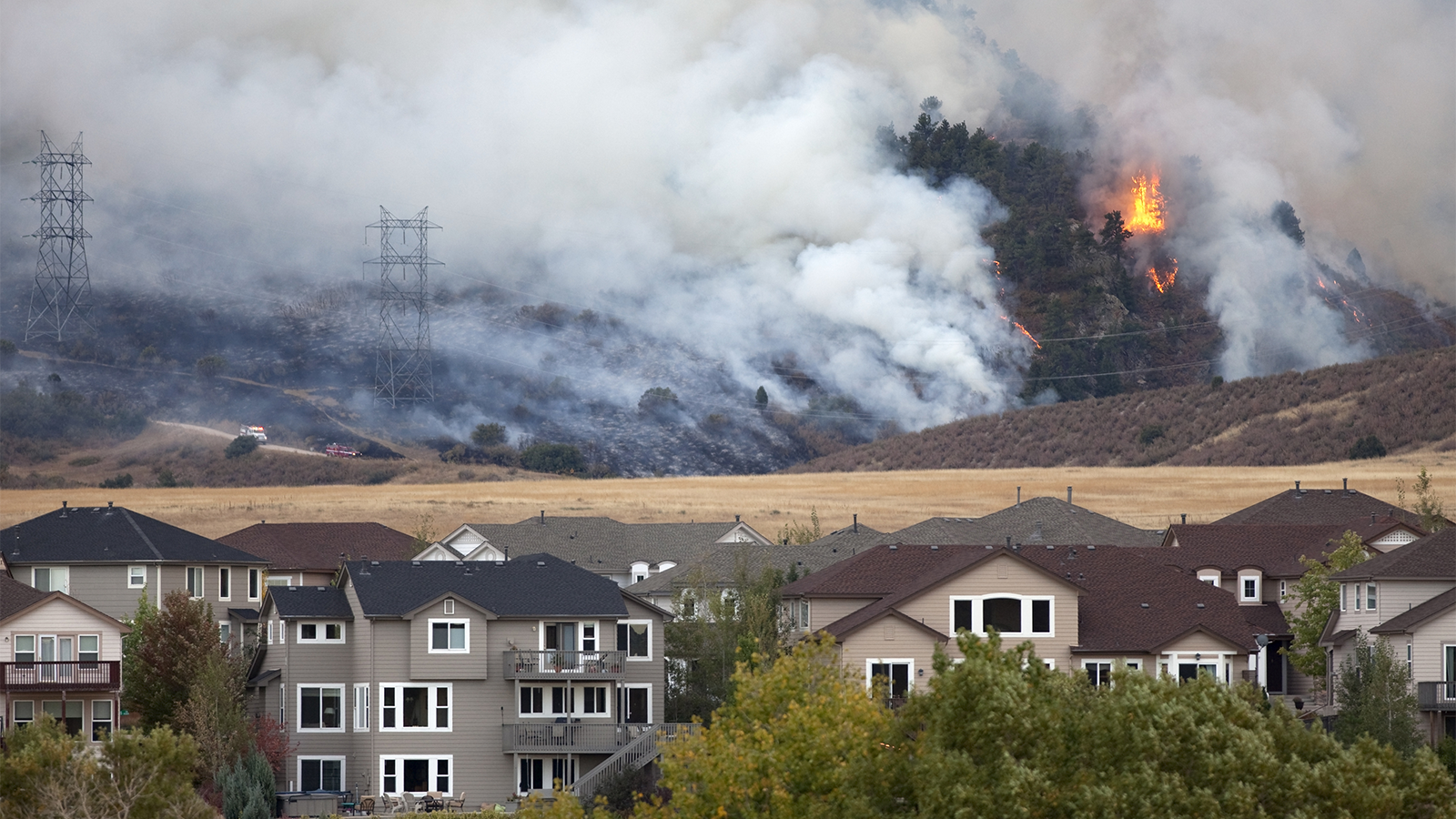wildfire in the distances with homes in the foreground