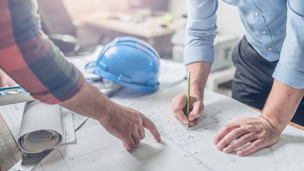 Two people working on a blueprint