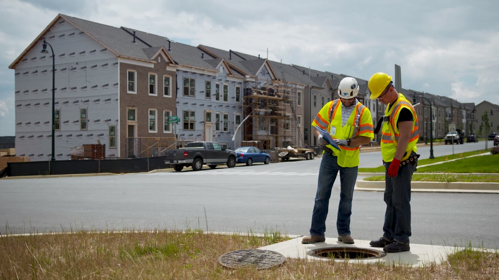 Construction workers examining a manhole