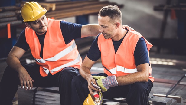 Two construction workers talking, one has hand on other's shoulder
