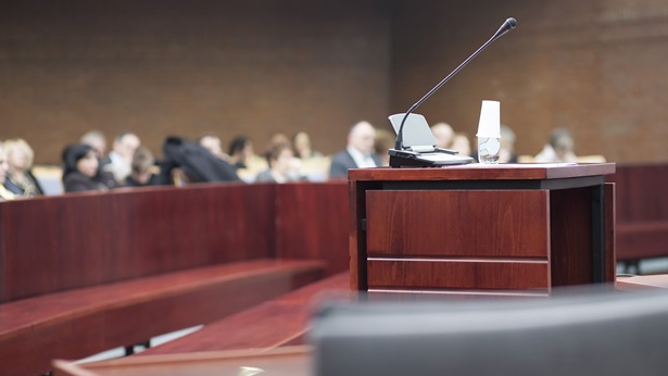 Courtroom podium with people in the gallery