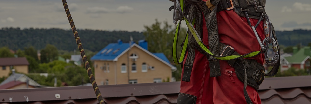 Roofer with fall protection harness