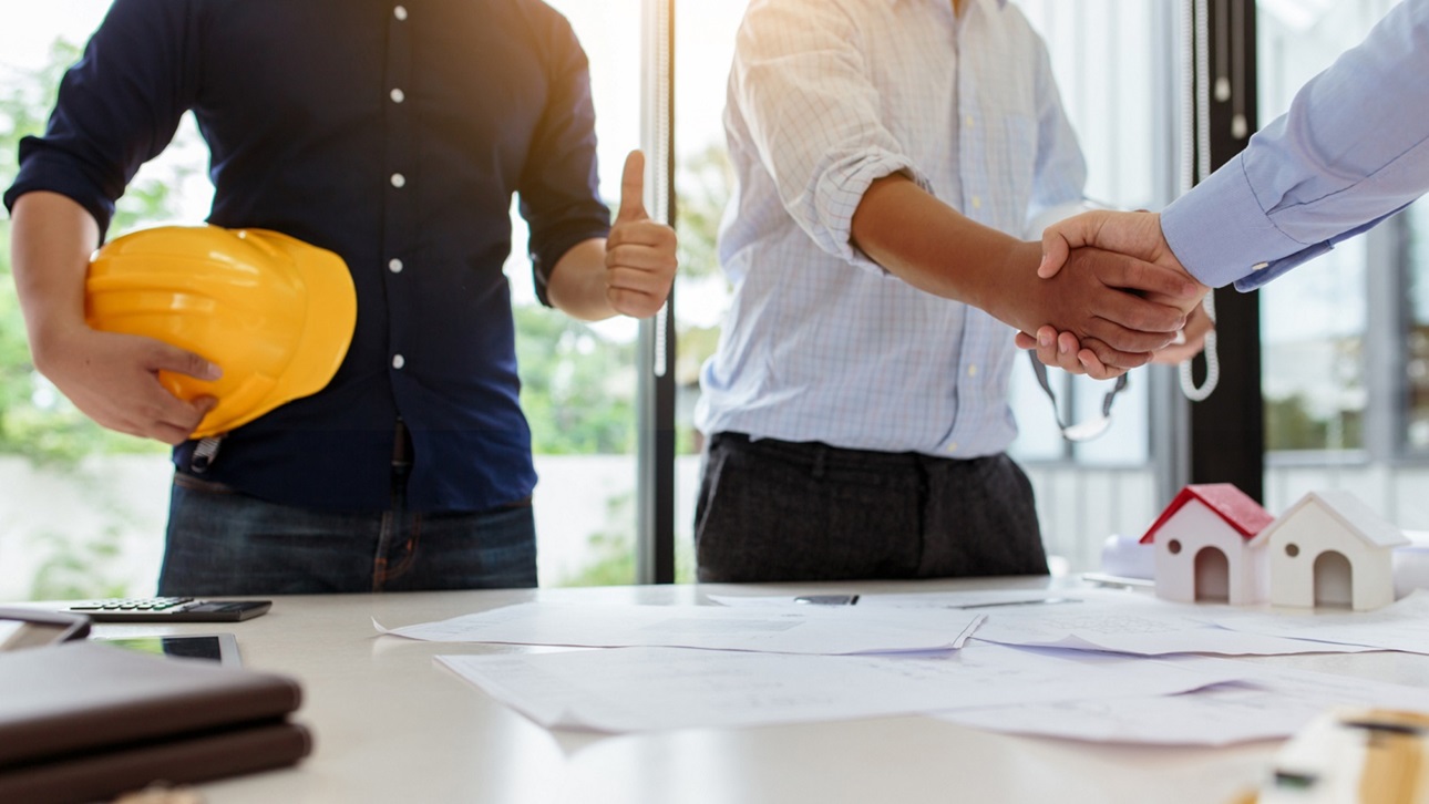 Builders shaking hands over a table