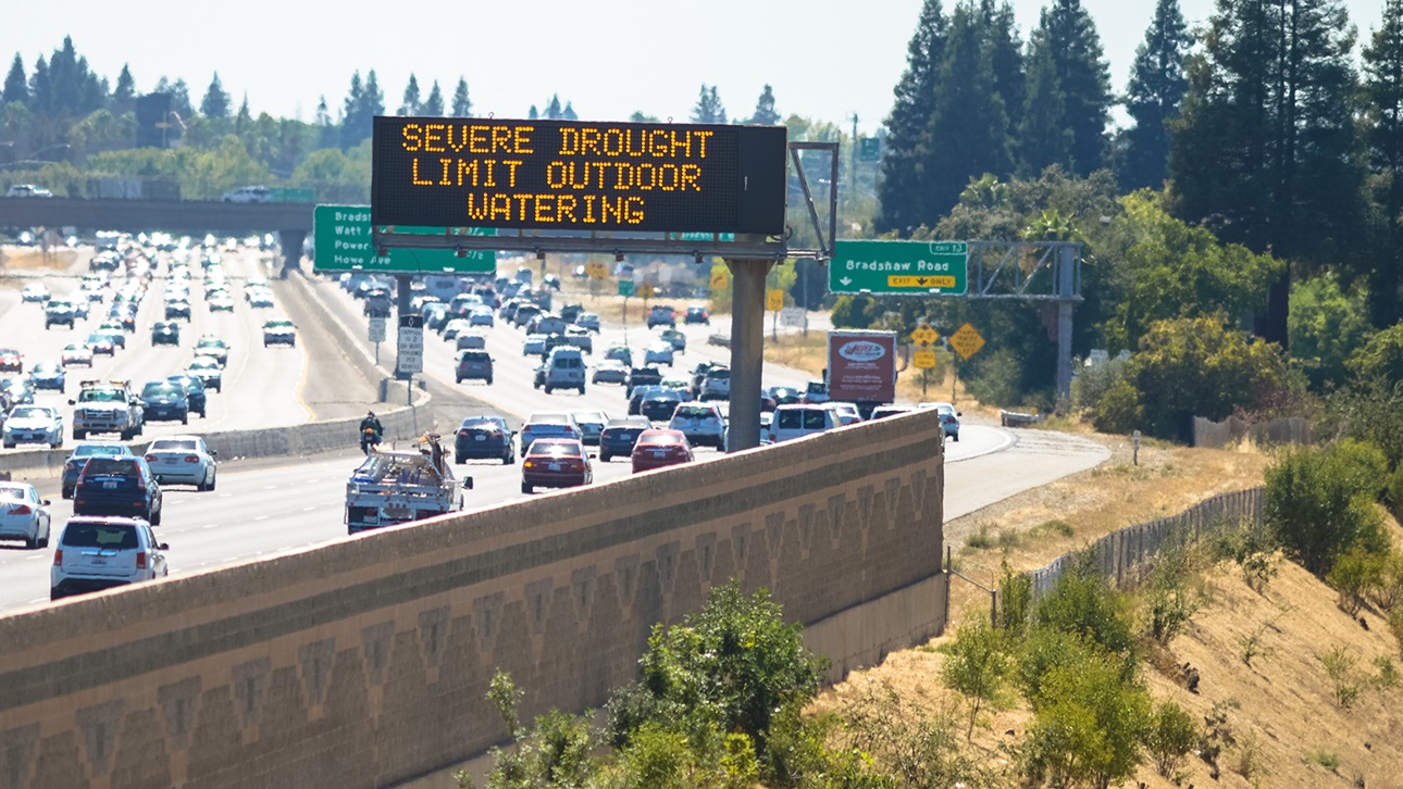 Severe drought sign above traffic on the highway