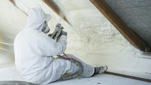Man spraying insulation in attic