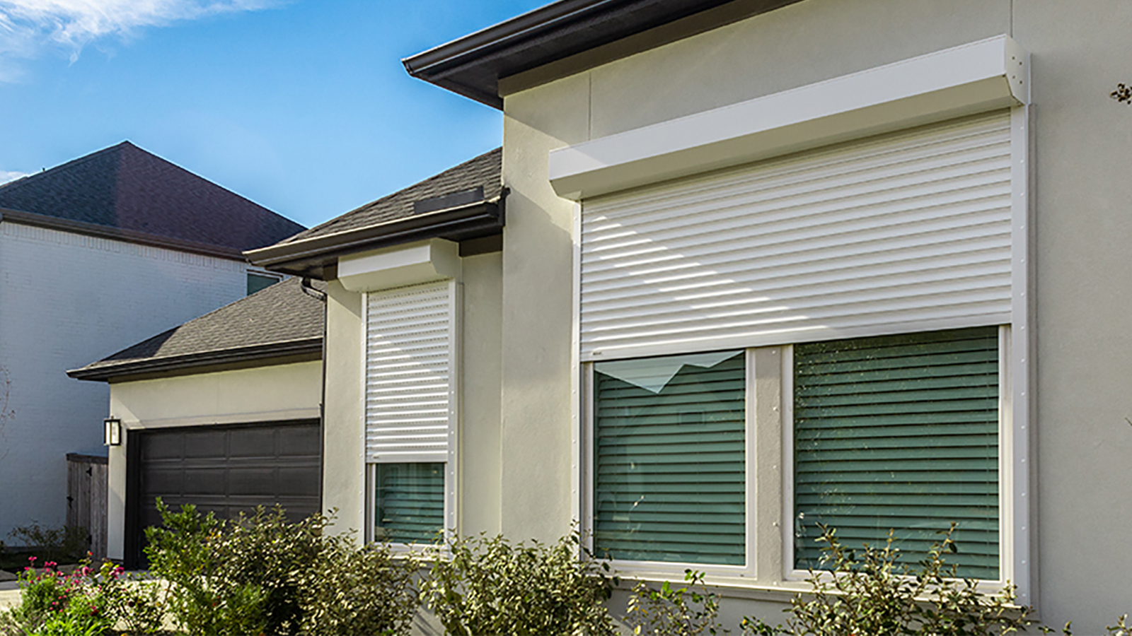 Hurricane shutters partially cover windows on a home