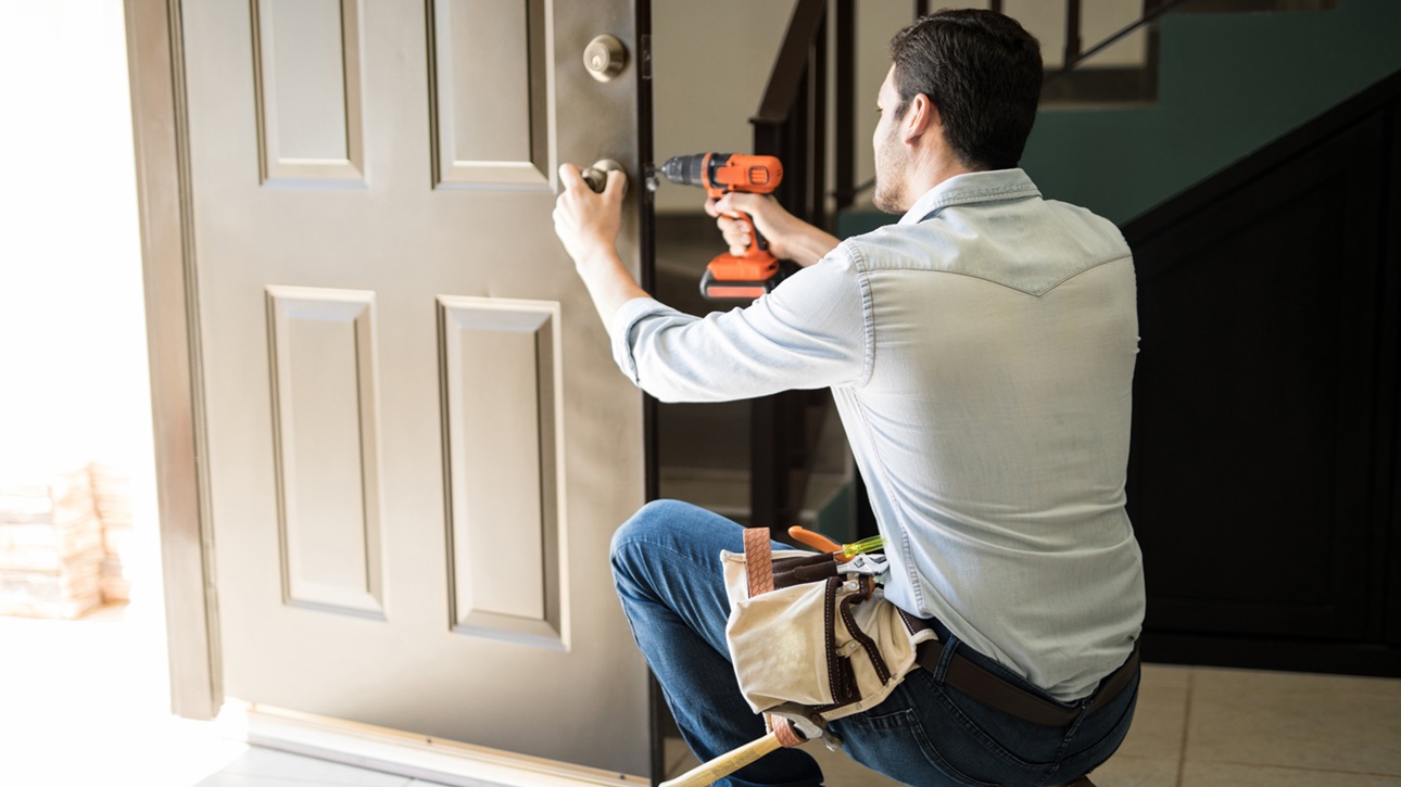 Worker putting finishes on front door to new home