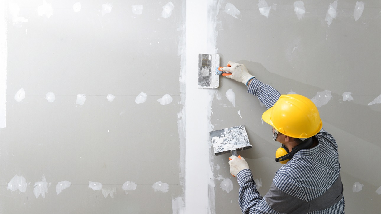 Worker finishing drywall installation