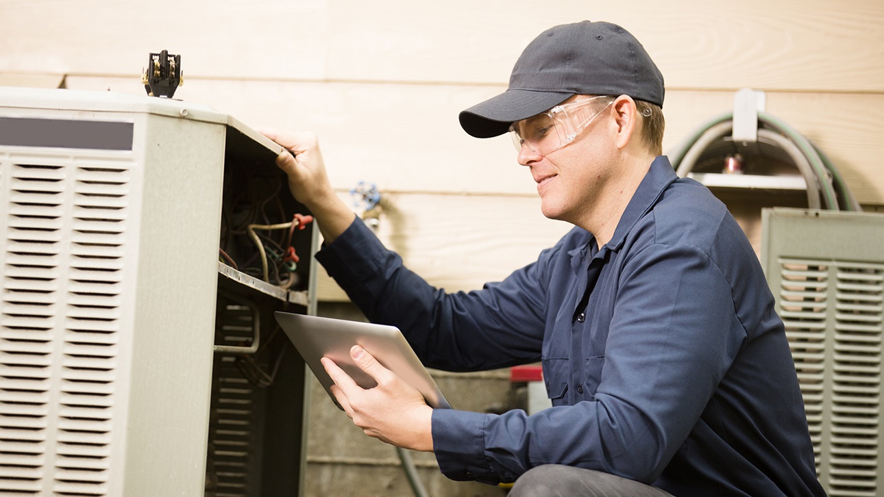 HVAC worker looking at a unit