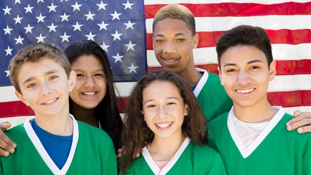 Five teenagers standing in front of the American flag