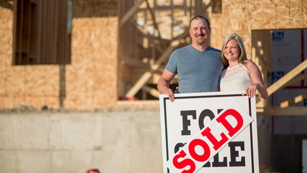 Couple holding sold sign