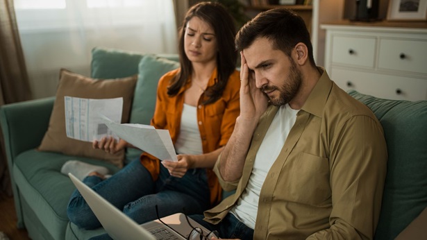 Discouraged young couple paying bills