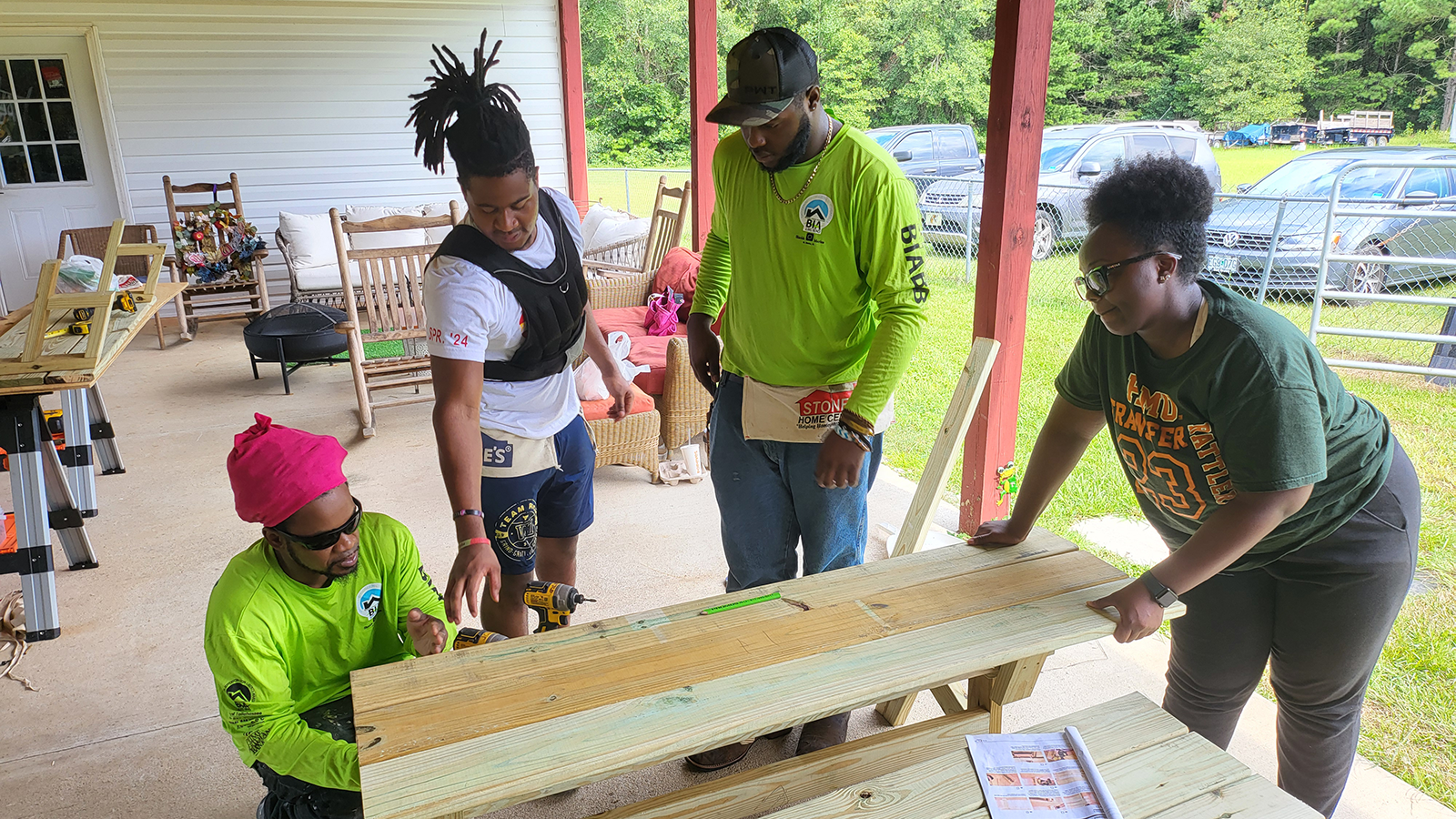 Students are guided through a building project by adult volunteers.