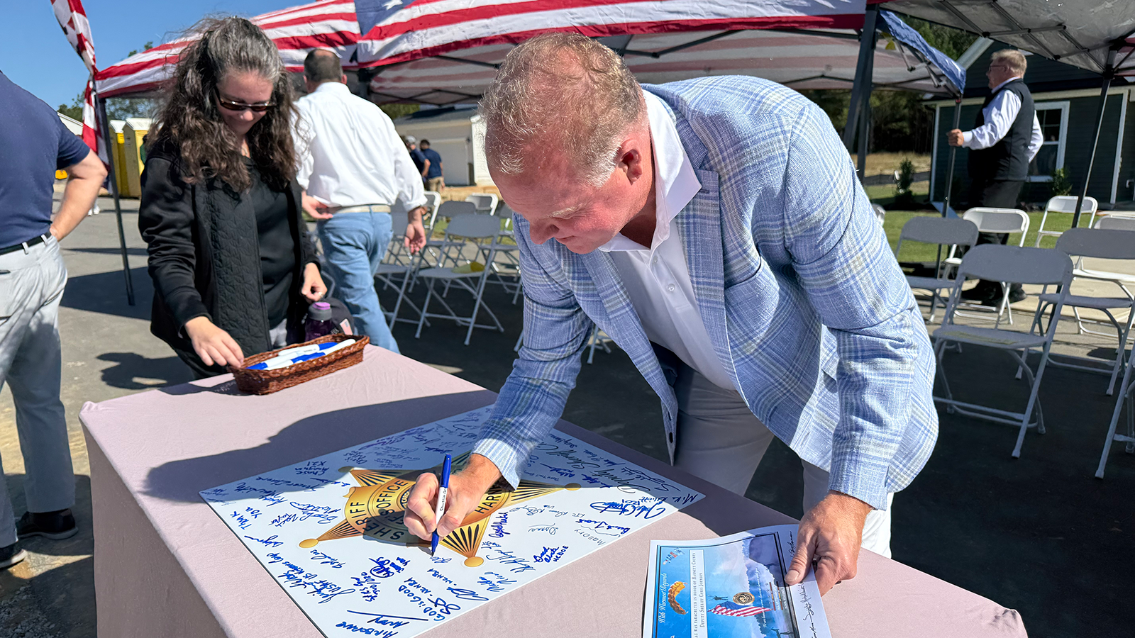 New Home Inc. owner Rich Van Tassel signs the shield in honor of Deputy Johnson.
