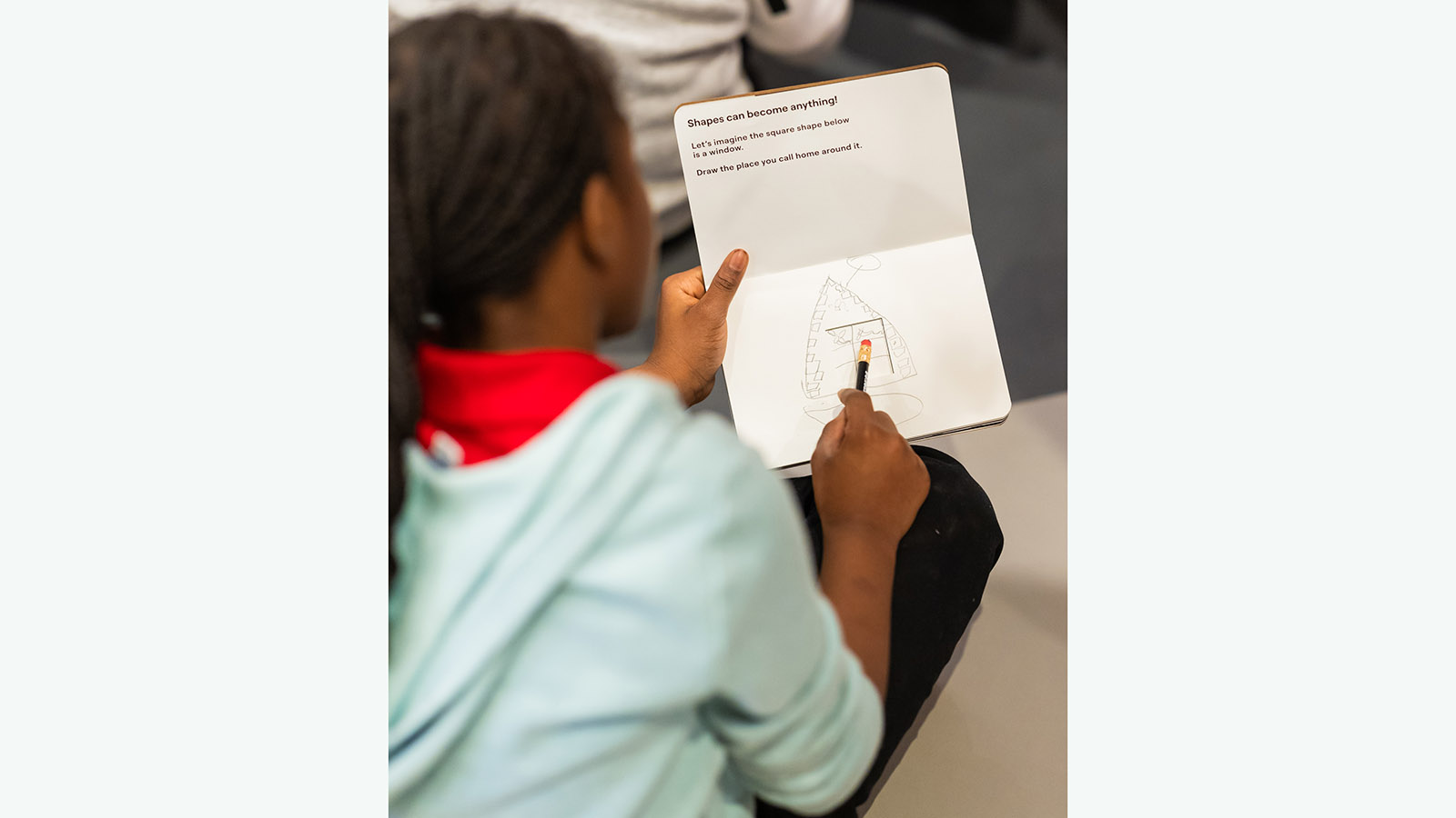 child draws in a sketch book