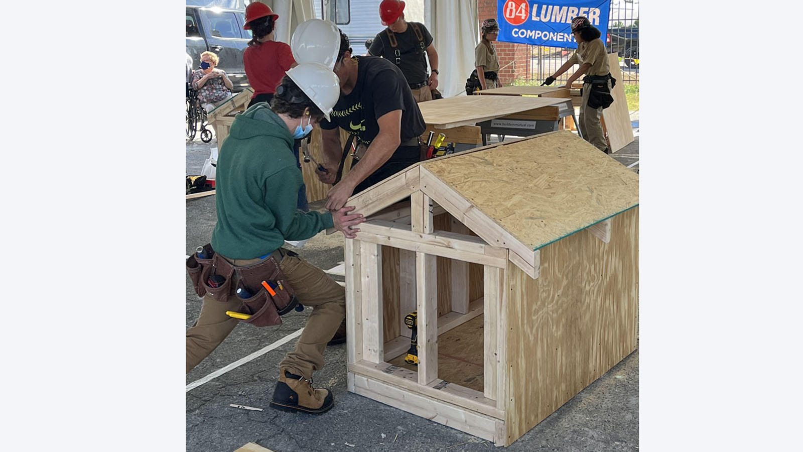 two male carpentry students assemble structure