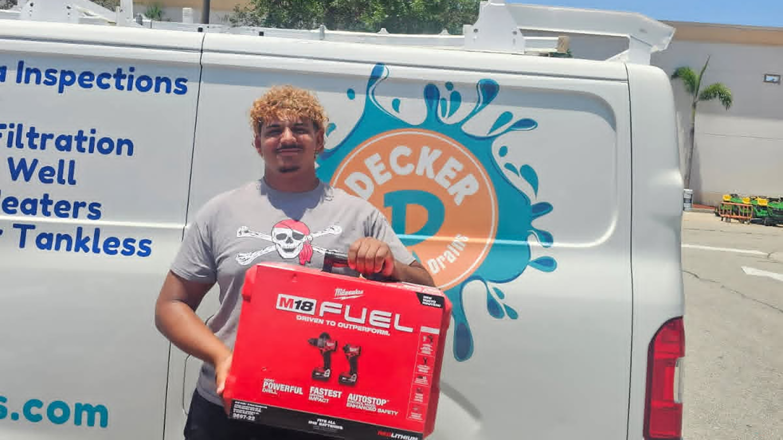 Student stands with a toolkit that he received through a workforce development grant.