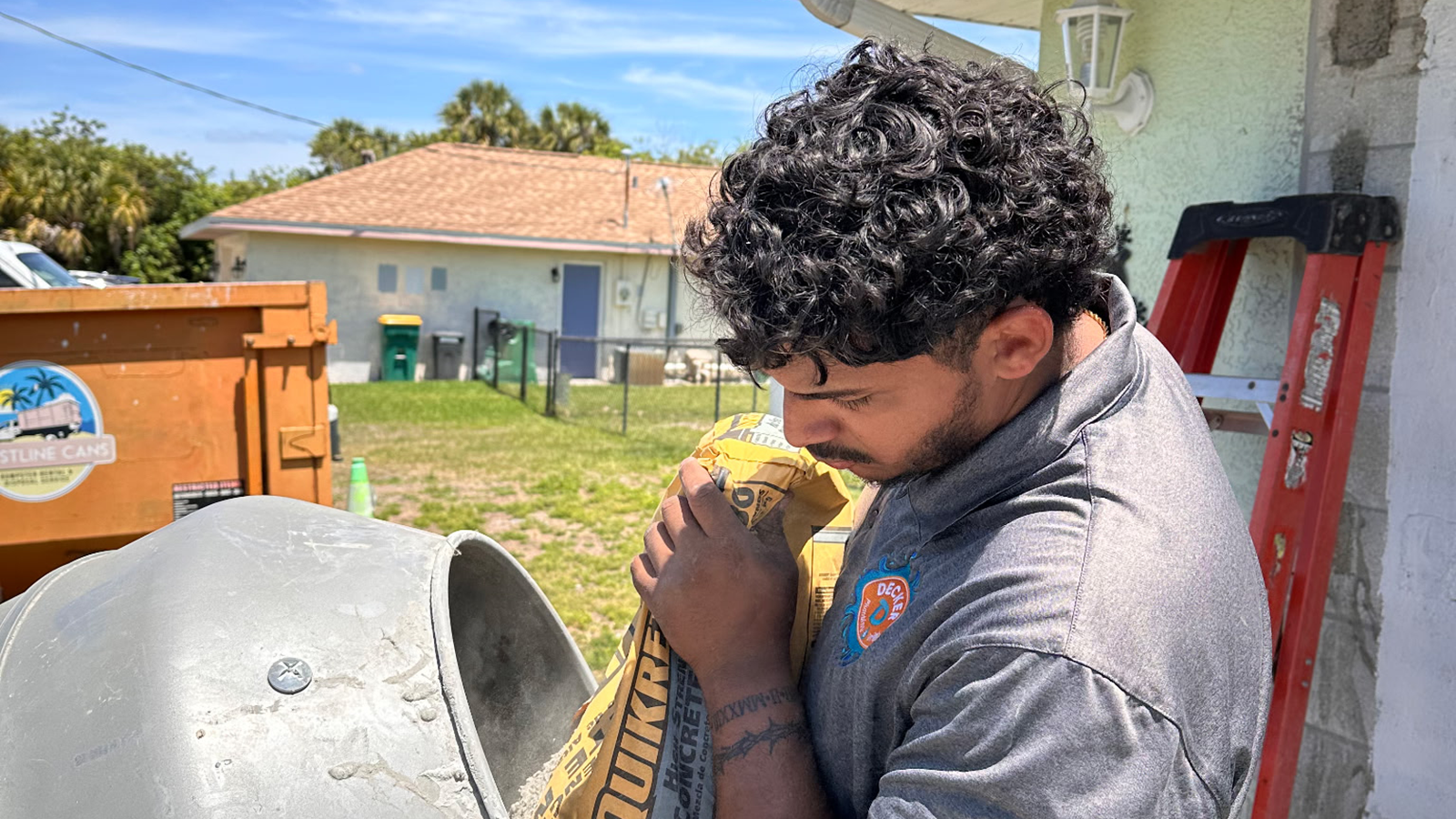 An apprentice uses a concrete mixer for a project.