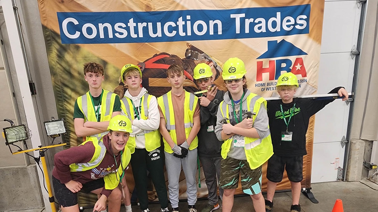 kids in construction gear in front of HBA sign