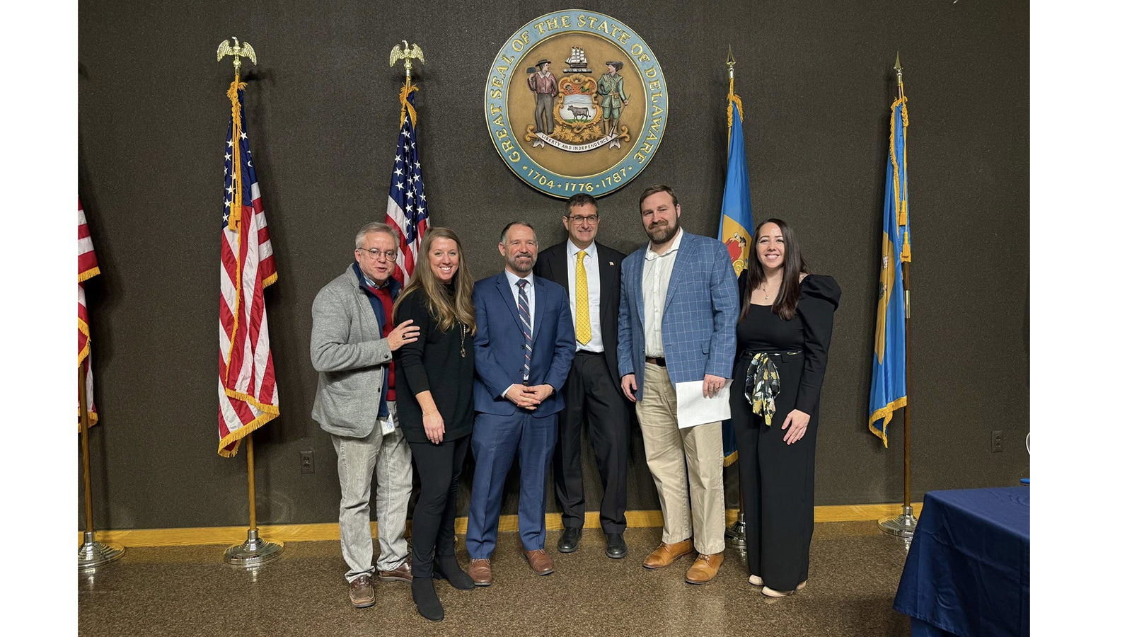 individuals in front of flags at state house