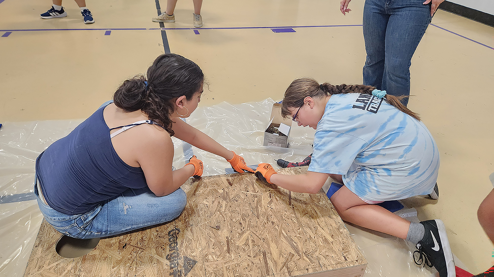 Local students build cornhole boards to practice their construction skills.
