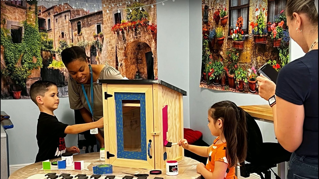 students paint little free library