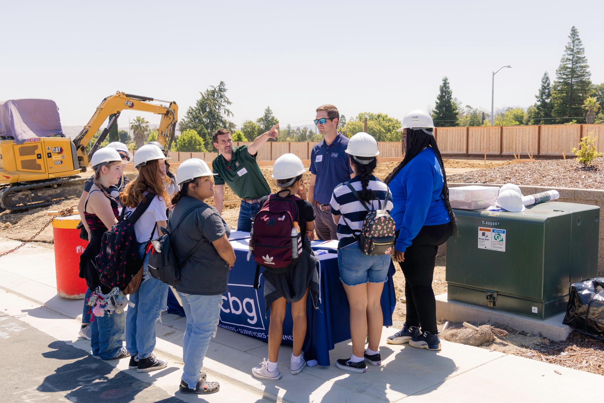 group of students wearing hard hats at a job site