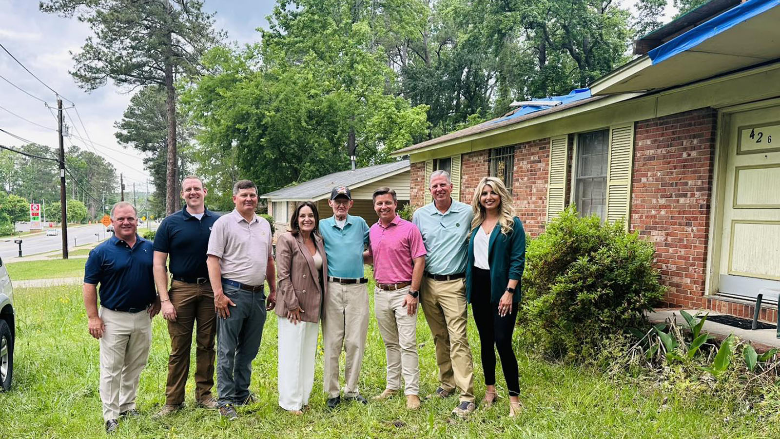hba leaders and members in front of house