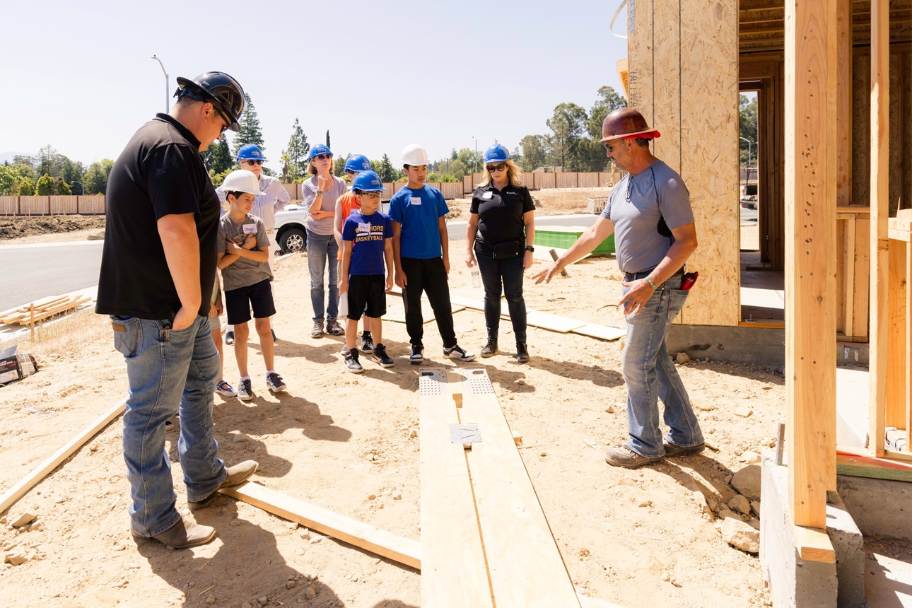 group of students visiting a home under construction