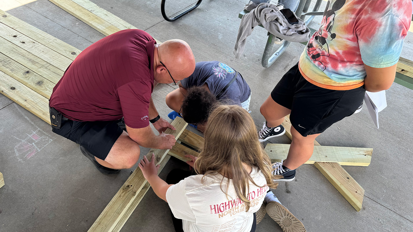 Students and member volunteers complete a picnic table build.