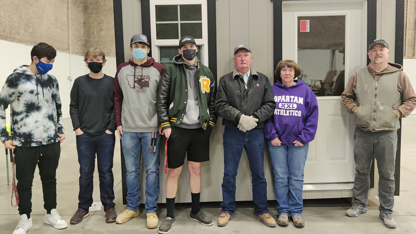 students pose in front of shed build