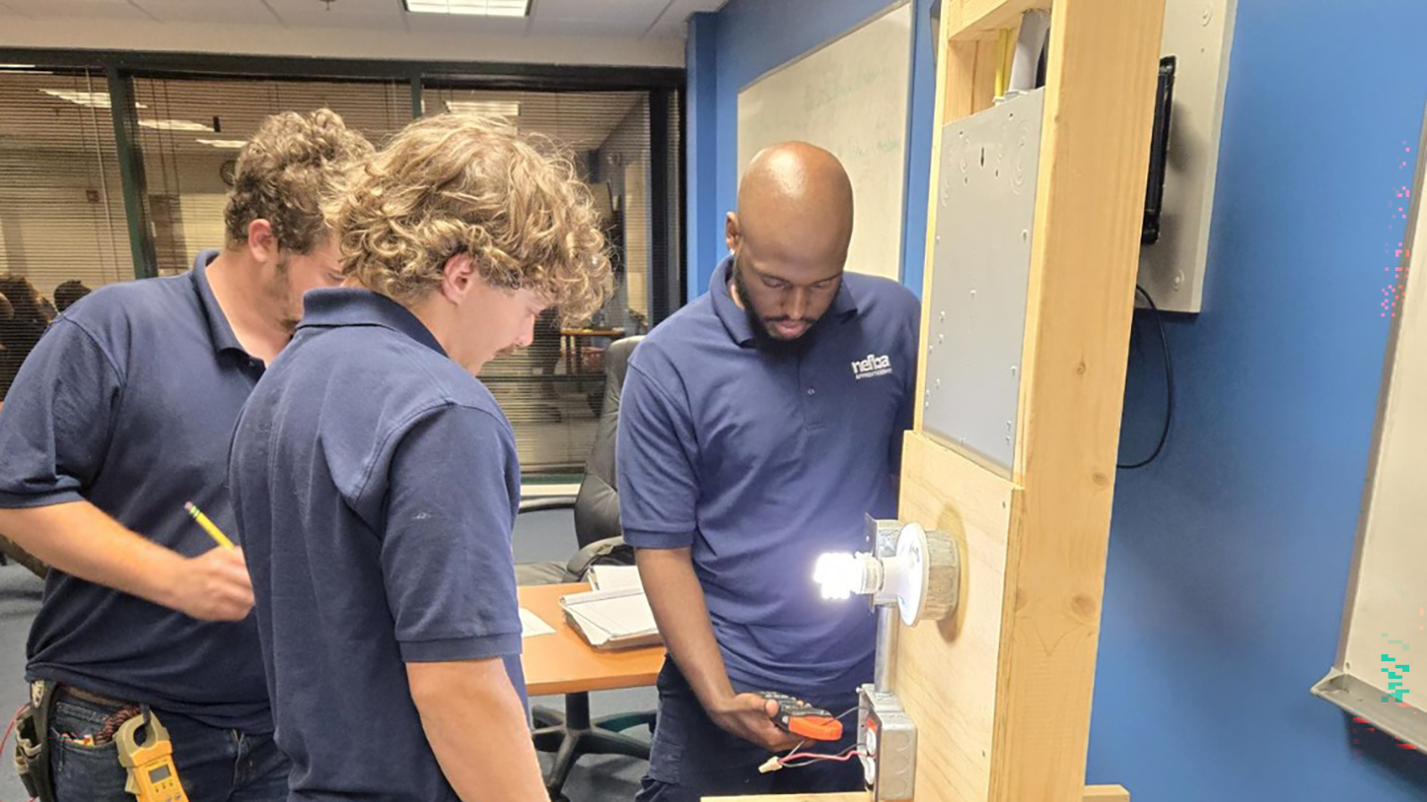 Students in the NEFBA Apprenticeship program are led through an electrical activity.