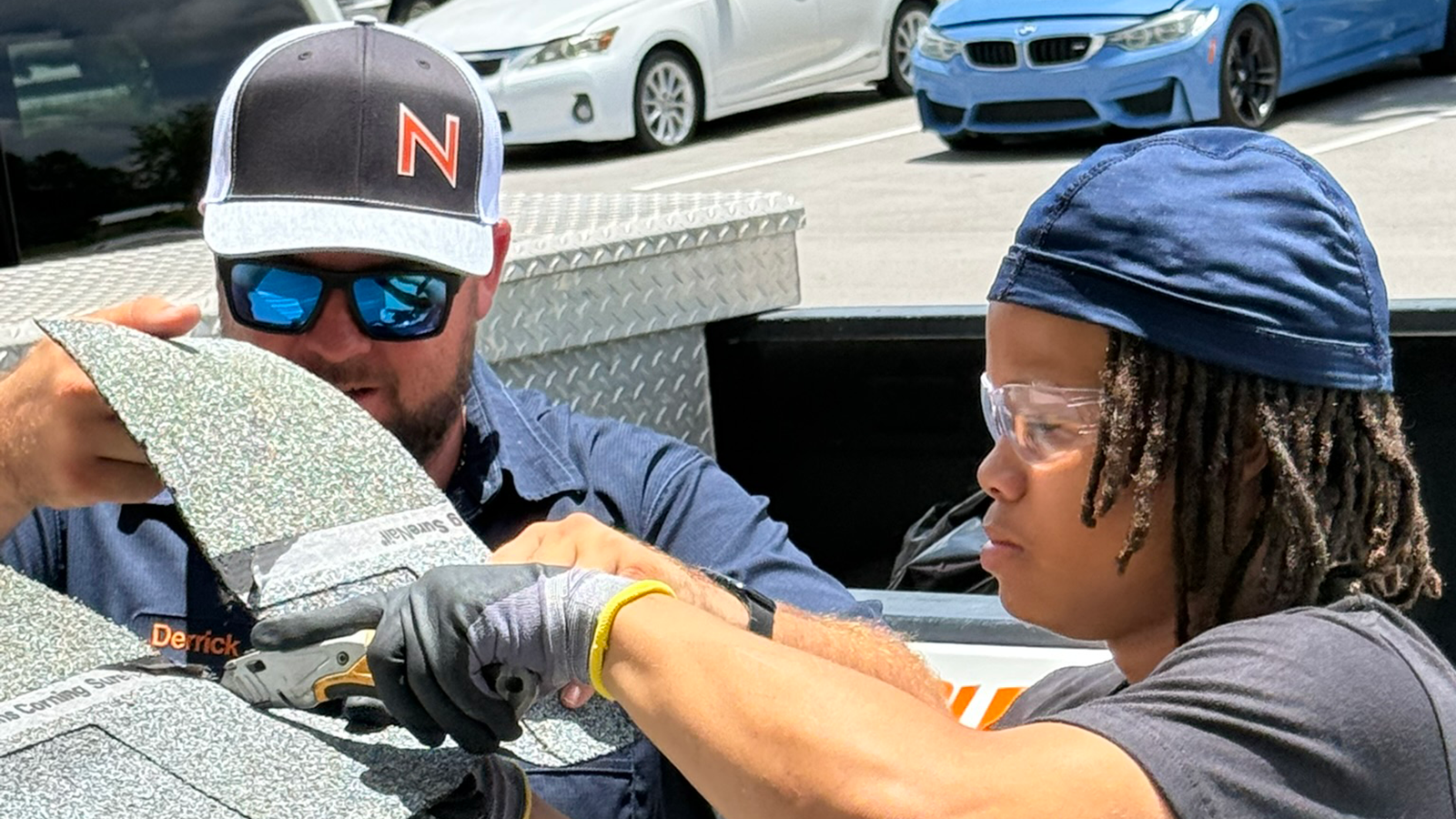 An adult volunteer guides a student through a project.