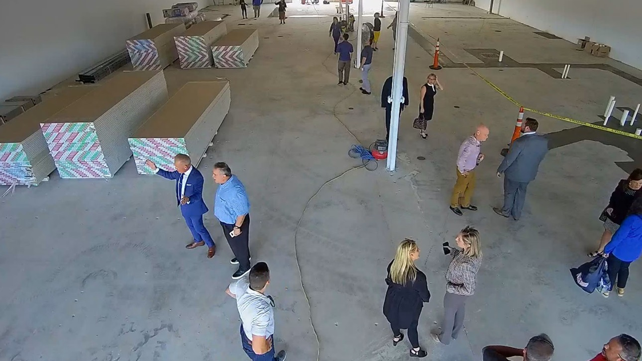 individuals looking around a large empty warehouse 