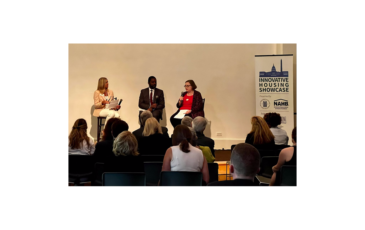 Alicia Huey moderates a panel on stage