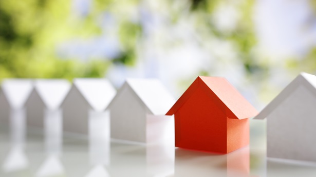 A row of white houses with a red one standing out