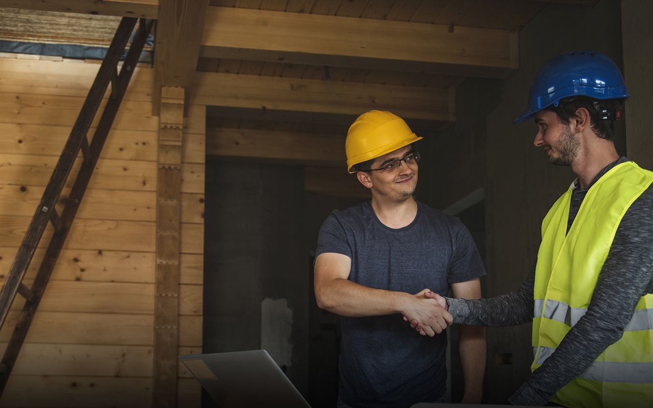 Two construction workers shaking hands