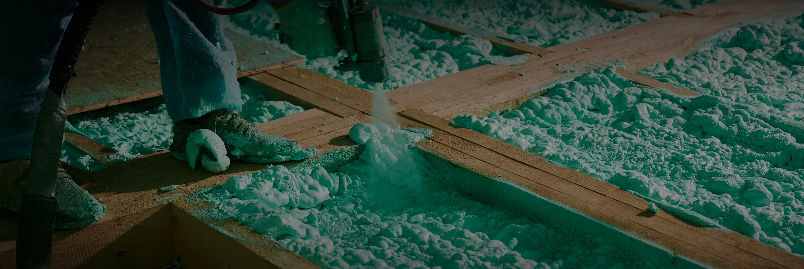 Worker applying spray foam insulation