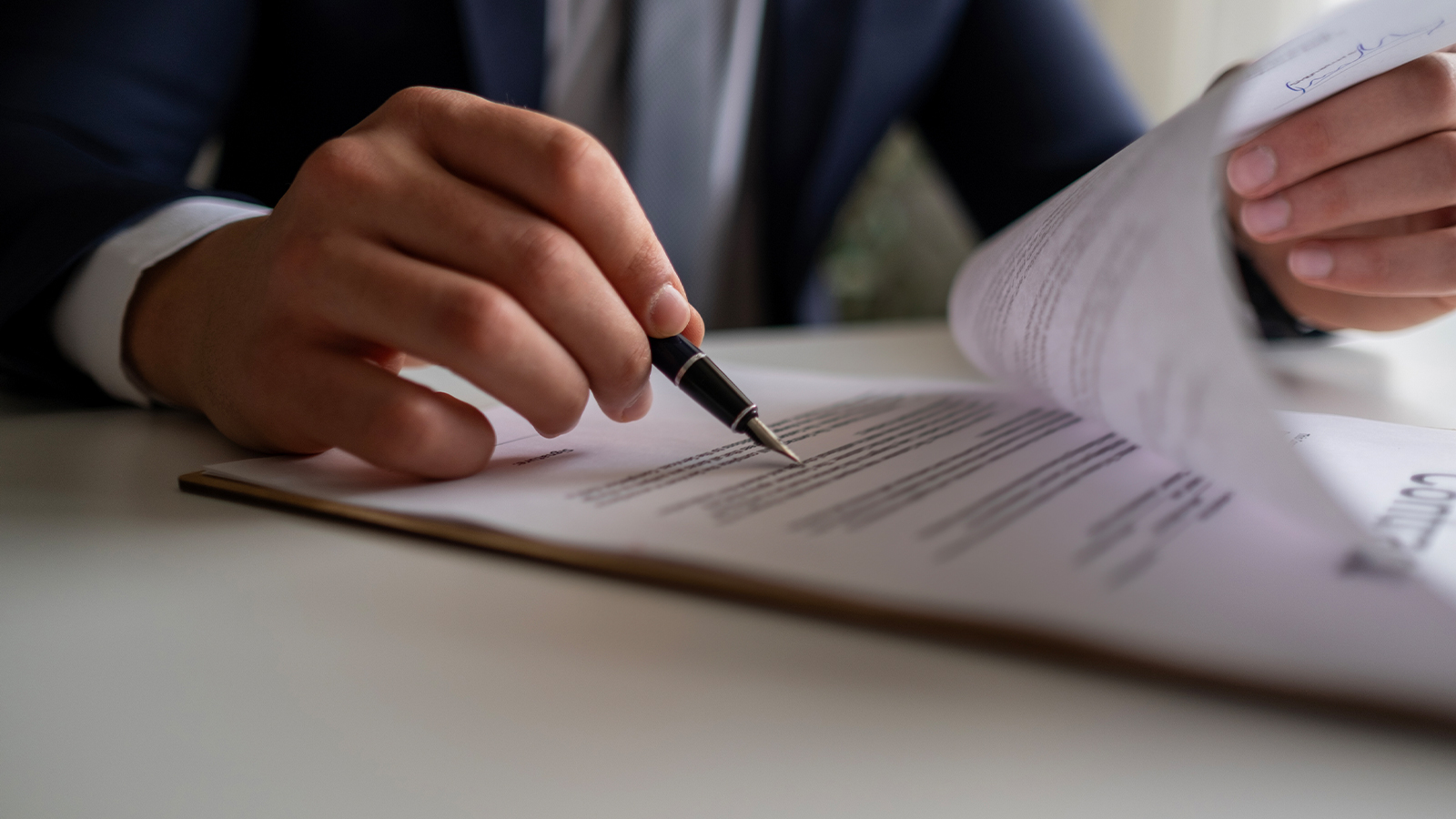 Man holding pen reading through documents
