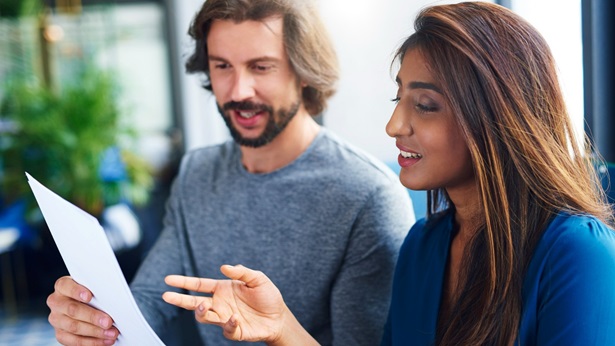 A man and woman reviewing a document