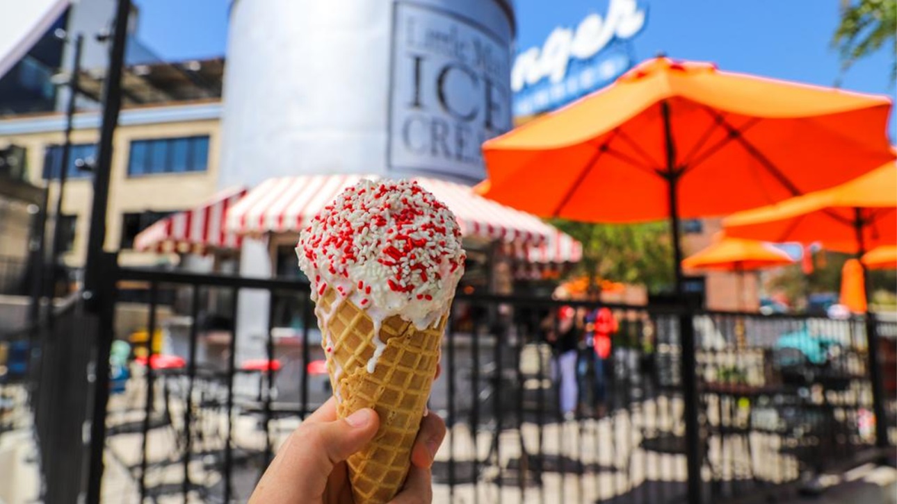 A man holding an ice cream cone in front of Denver's Little Man Ice Cream Shop