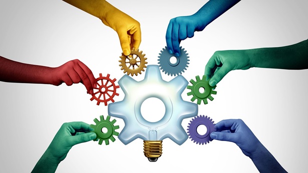 Hands adding small gears to one large gear concept