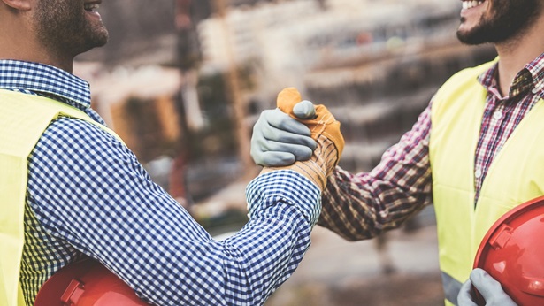Two construction workers uniting
