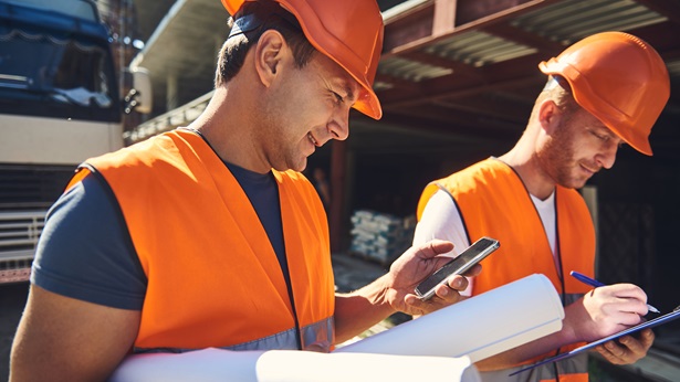 Construction workers looking at phone