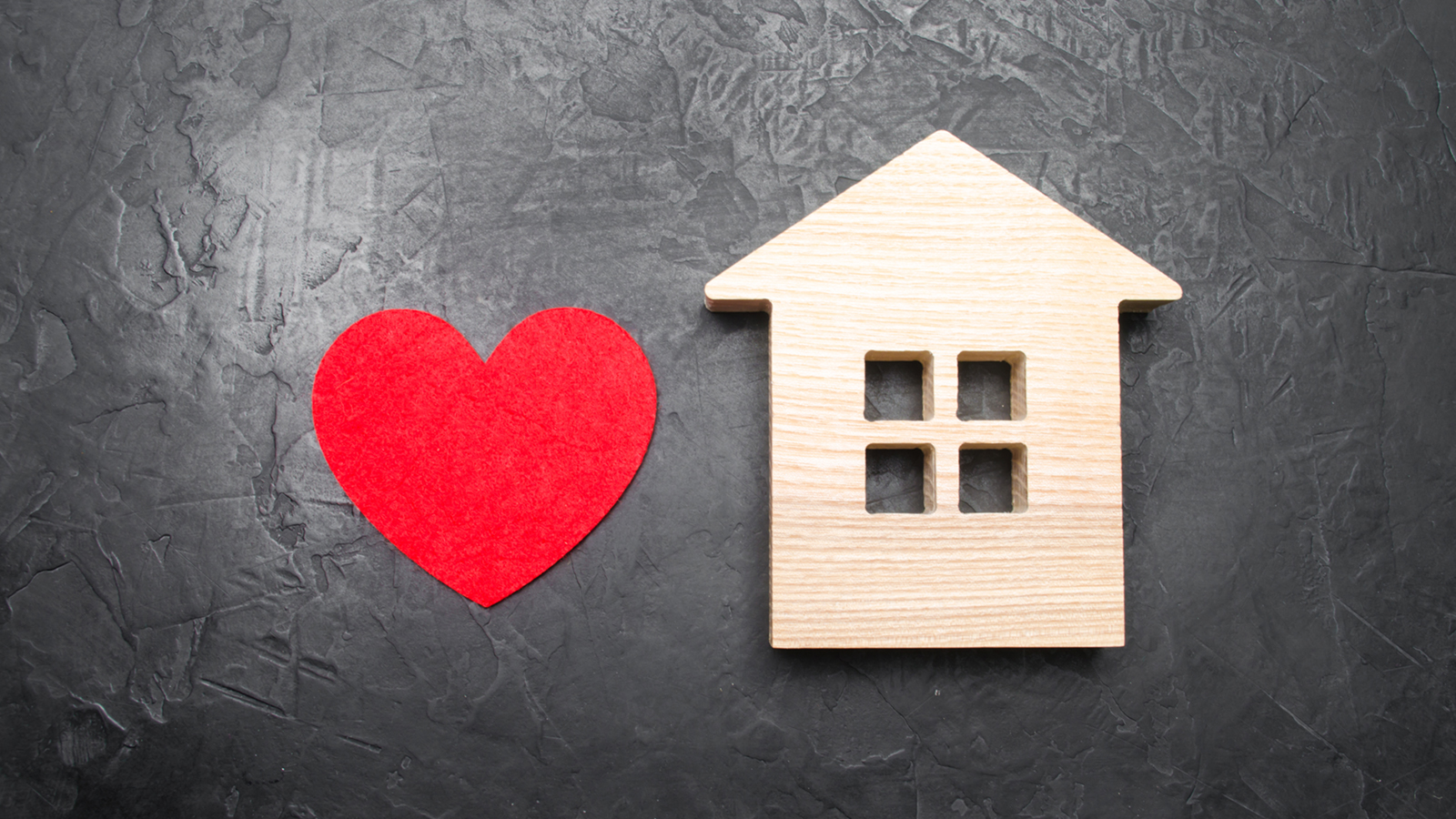 A heart next to a wooden toy house